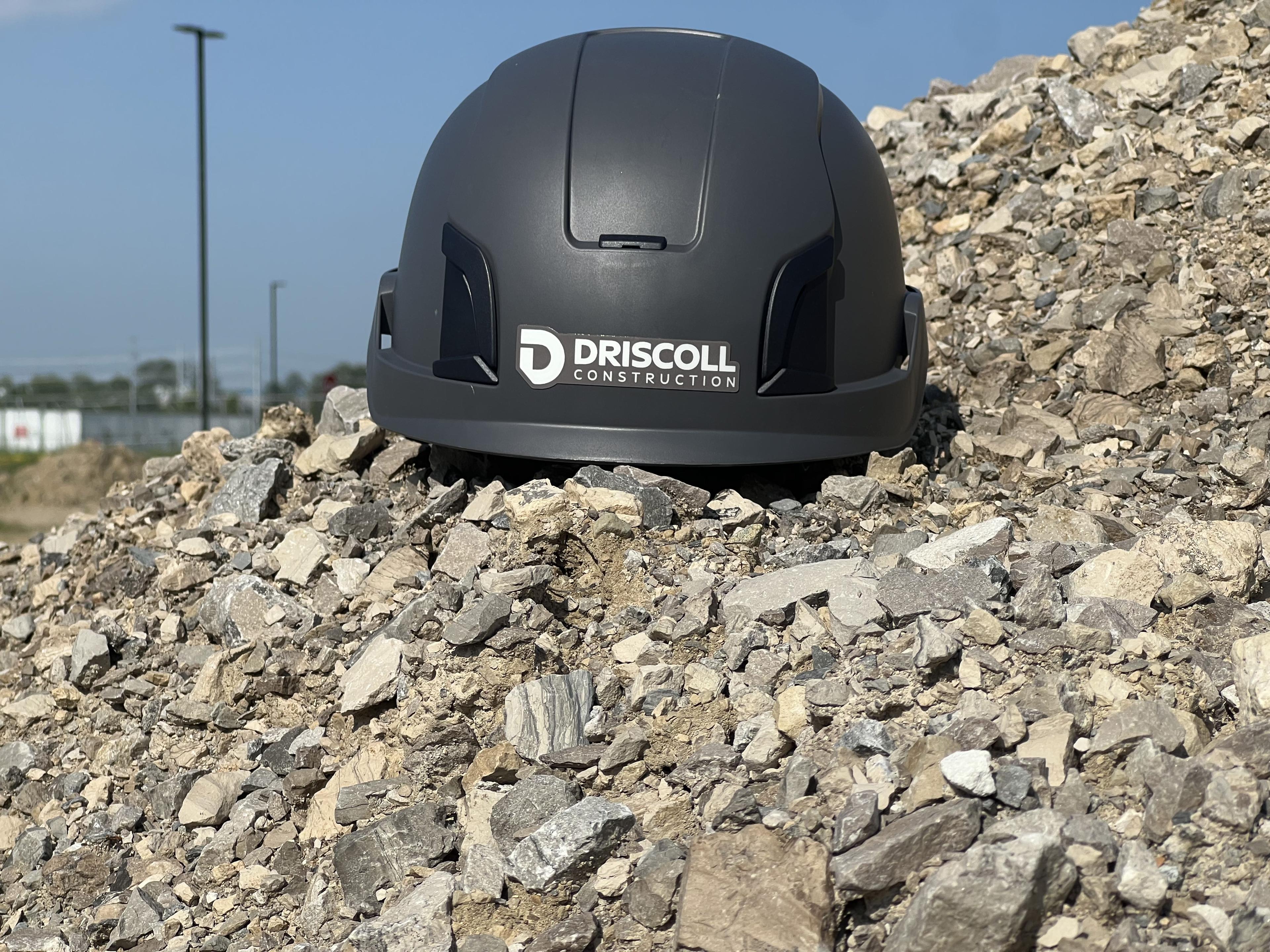 Driscoll Construction branded helmet on a jobsite